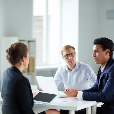 three people seated at a table talking